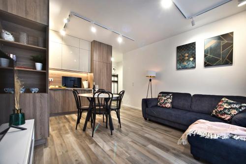 ein Wohnzimmer mit einem Sofa und einem Tisch in der Unterkunft Goclaw P&O Serviced Apartments in Warschau