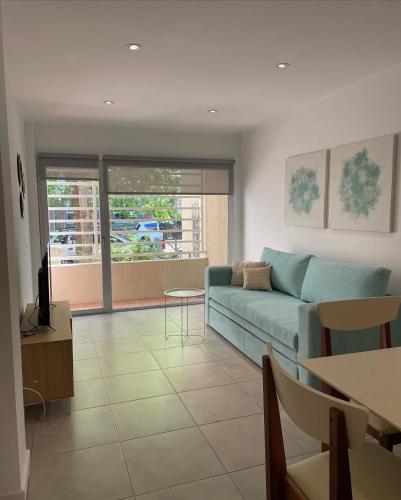 a living room with a blue couch and a table at Administración Maipu PB A Depto Premium in Tandil