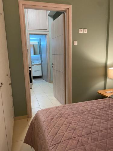 a bedroom with a bed and a door leading to a bathroom at CASA MILITOU-NEA FILADELFIA in Athens