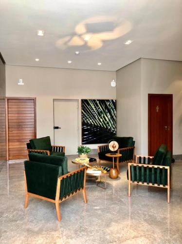 a lobby with green chairs and a table at Serravita Hotel in Piumhi