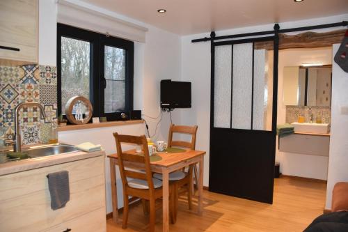 Una cocina con una mesa y un comedor. en Le Gîte du Pic Vert, en Ciplet