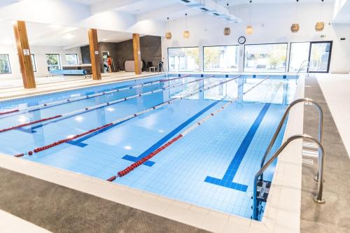 una gran piscina cubierta con azulejos azules en JJ Sport Concept Hotel en Cracovia