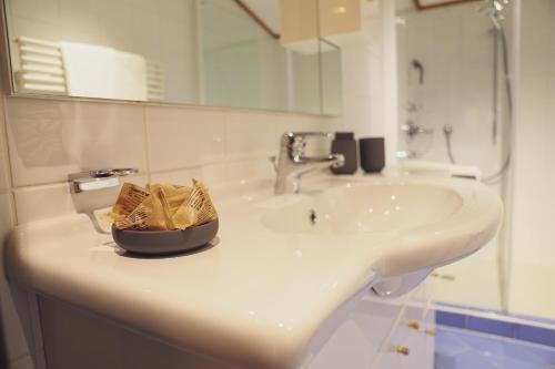 a bathroom sink with a bowl of chips on it at Mocking Ferienappartements in Kitzbühel