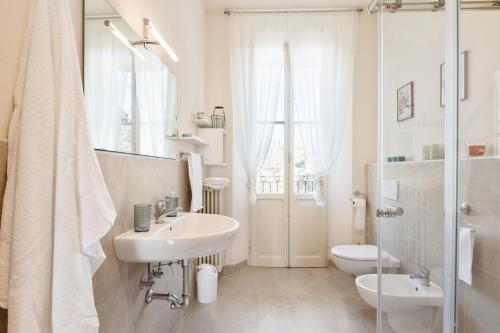 a white bathroom with a sink and a toilet at AriediParma Appartamenti in Parma