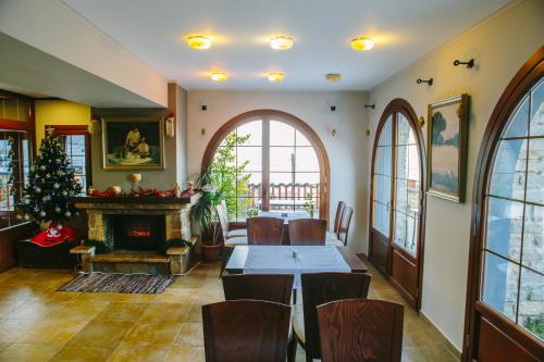 a dining room with a table and a fireplace at Grand Hotel Dentro in Konitsa