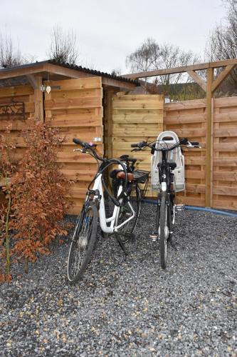 Dos bicicletas estacionadas frente a una valla en Le Gîte du Pic Vert, en Ciplet
