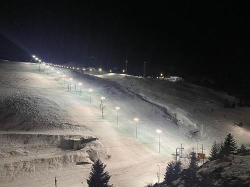 a snow covered slope with street lights at night at Villa 80 Kodra e Diellit in Tetovo