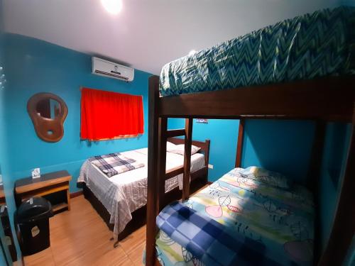 a bedroom with two bunk beds and a bed at Coral Reef Surf Hostel and Camp in Tamarindo