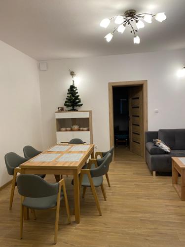 une salle à manger avec une table, des chaises et un arbre de Noël dans l'établissement Noclegi Dukla, à Dukla