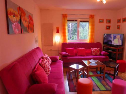 ein Wohnzimmer mit einem lila Sofa und einem Tisch in der Unterkunft Apartman Happy in Zlatibor