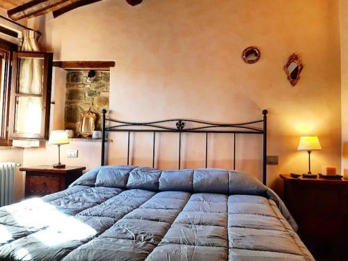 uma cama grande num quarto com 2 candeeiros em Le Torri San Gimignano Apartments em San Gimignano