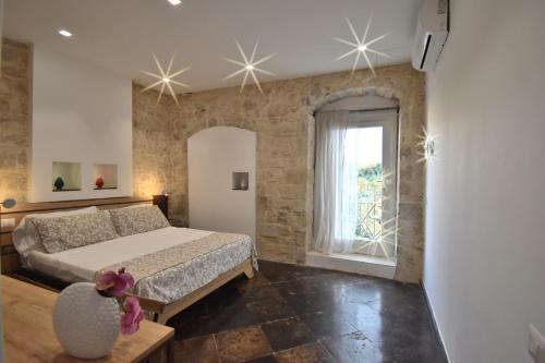 een slaapkamer met een groot bed en een raam bij B&B Cuore Barocco in Ragusa