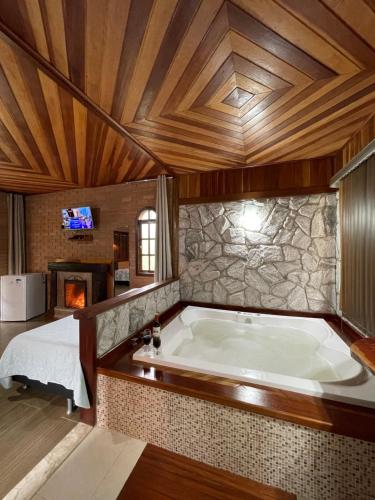 un ampio bagno con vasca e letto di Pousada Solar Das Águas, S/N a Visconde De Maua