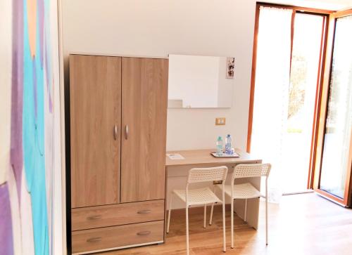 a kitchen with a desk and two chairs and a cabinet at IL VILLAGGIO DELLE FATE in Macerata
