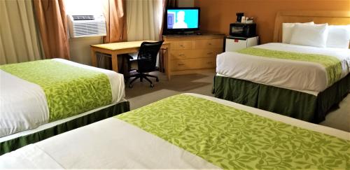 a hotel room with two beds and a desk at Lyons Inn in Lyons