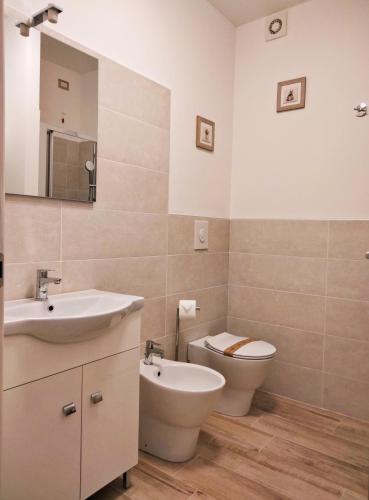 a bathroom with a sink and a toilet and a mirror at IL VILLAGGIO DELLE FATE in Macerata