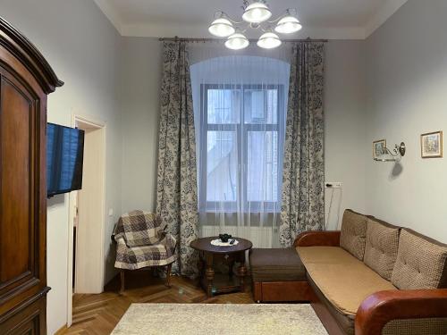 a living room filled with furniture and a window at Kurnakh Apartment in Lviv