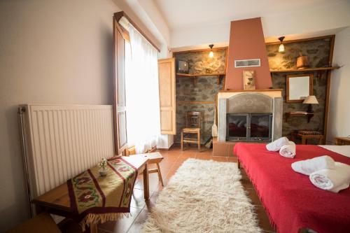 a living room with two beds and a fireplace at Ξενώνας Πατρικό in Neraïdochóri