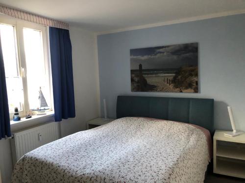 Un dormitorio con una cama y un cuadro en la pared. en Darsskrabbe, en Prerow