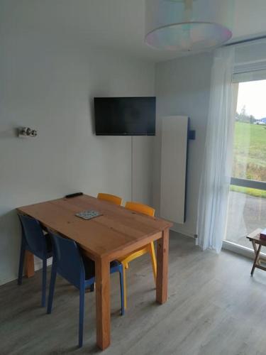 a dining room with a wooden table and chairs at Le Cozy du Poli, Résidence Le Haut des Lacs in Xonrupt-Longemer