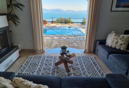 a living room with a view of a pool at Villa Boukari in Chlomós