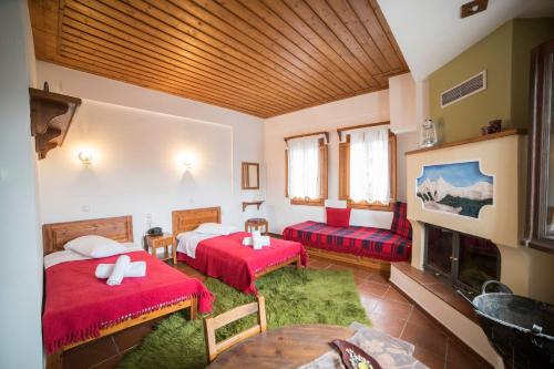 a hotel room with two beds and a fireplace at Ξενώνας Πατρικό in Neraïdochóri