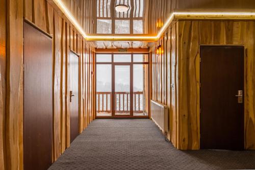 a hallway with wooden walls and a door and a window at Rich OAK - готель з відкритим панорамний басейном in Yablunytsya