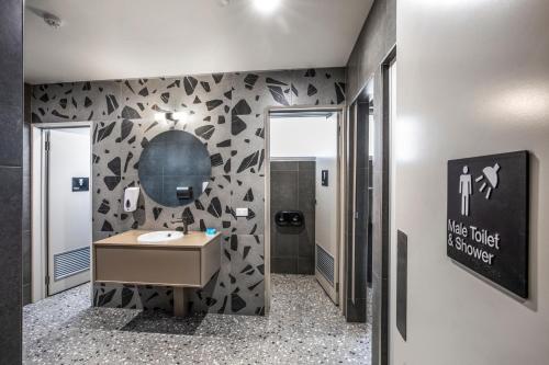 a bathroom with a sink and a black and white wall at Royal Hotel by Nightcap Social in Melbourne