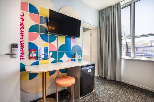 a room with a desk and a colorful wall at Royal Hotel by Nightcap Social in Melbourne