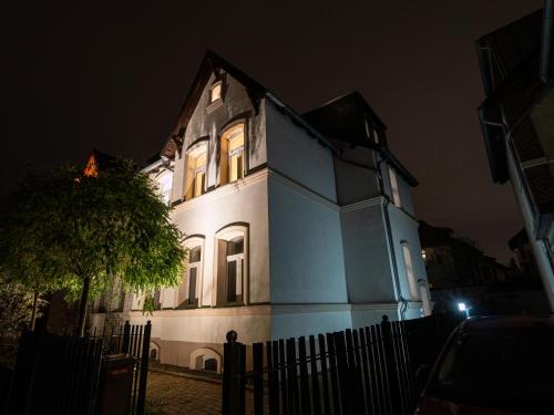 een blauw-wit huis met een boom ervoor bij Charmantes Apartment in Hannover in Hannover