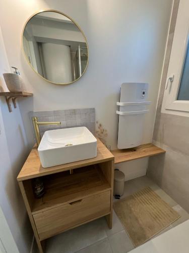 une salle de bain avec un lavabo blanc et un miroir dans l'établissement Les Embruns, océan et centre ville à pied, à Capbreton