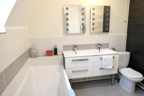 Baño blanco con lavabo y aseo en Maison de 3 chambres avec vue sur la ville et wifi a Arques la Bataille, en Arques-la-Bataille