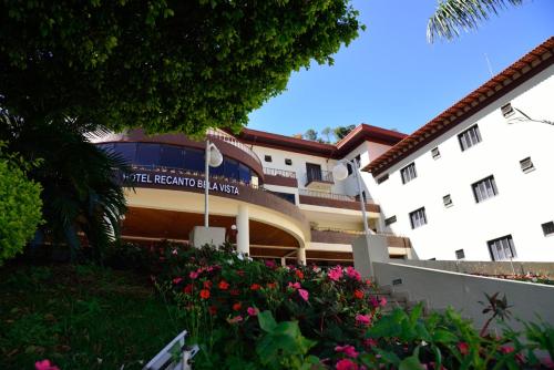 a large building with flowers in front of it at Hotel Recanto Bela Vista in Águas de Lindóia