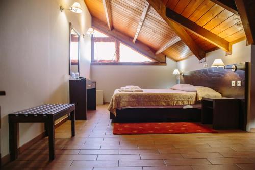 a bedroom with a bed and a bench in a room at Grand Hotel Dentro in Konitsa