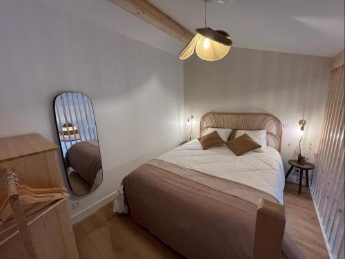 a bedroom with a bed and a large mirror at Les Embruns, océan et centre ville à pied in Capbreton