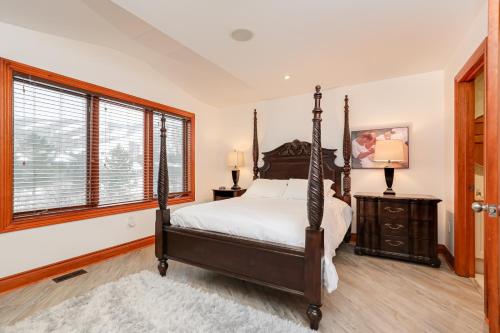 a bedroom with a canopy bed and a window at Blue Mountain-Luxurious BlueSki George Chalet, Hot Tub, Pool, Gas Fireplace in Blue Mountains