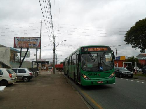 庫里奇巴的住宿－Assel Pousada Xaxim，一辆绿色的巴士沿着街道行驶