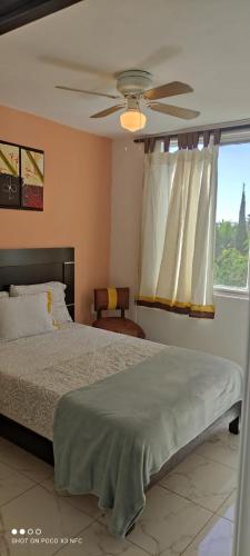 a bedroom with a bed and a ceiling fan at Casa Armony in Cuernavaca