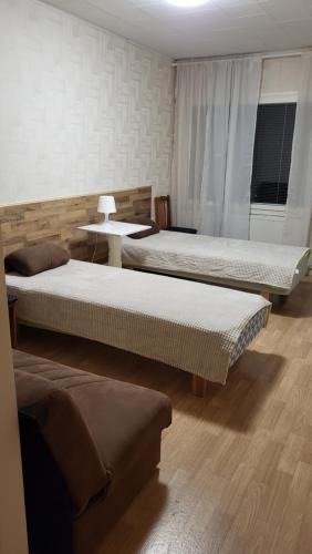 Habitación con 3 camas y sofá en Mini-Mani Northern House, en Sorsakoski