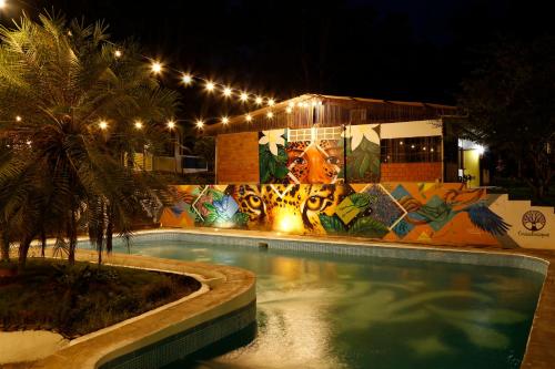 una piscina por la noche con una pared con graffiti en CasaBosque, en Tarapoto