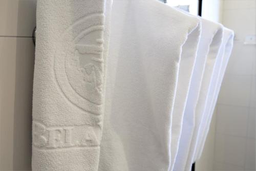 a white towel hanging on a towel rack at Hotel Recanto Bela Vista in Águas de Lindóia