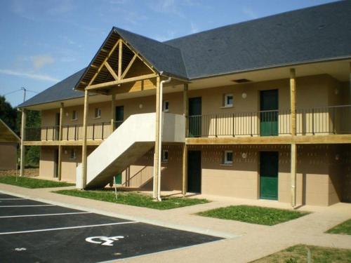 an apartment building with a staircase in a parking lot at Entre le Pont 9 et l'Eveque , Les Hauts de Honfleur, Piscine, WIFI et Parking gratuits in Équemauville