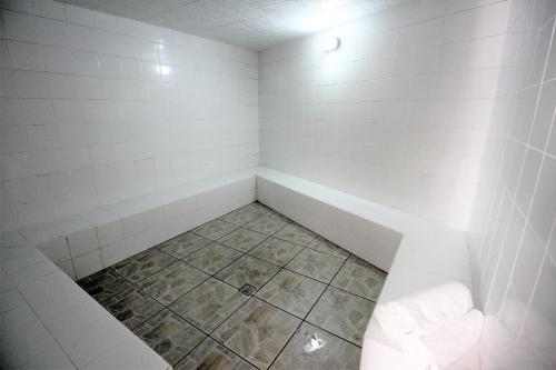 a corner of a bathroom with a tub and a tile floor at Hotel Recanto Bela Vista in Águas de Lindóia