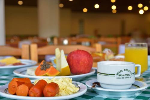 a table with plates of food and a cup of coffee at Hotel Recanto Bela Vista in Águas de Lindóia