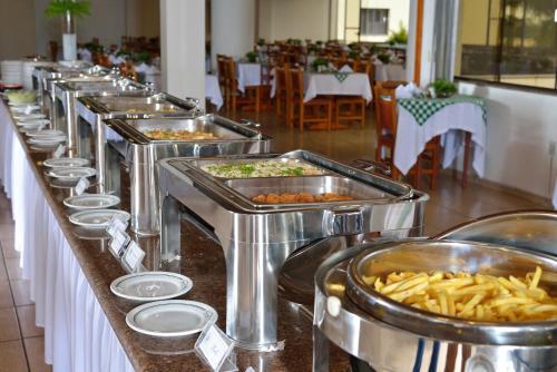 a row of trays of food on a buffet line at Hotel Recanto Bela Vista in Águas de Lindóia