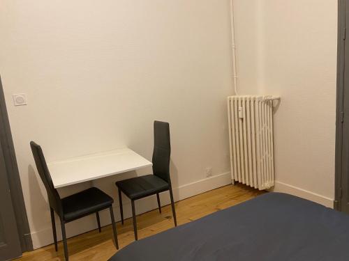 une chambre avec une table, deux chaises et un radiateur dans l'établissement Le Semnoz, à Annecy