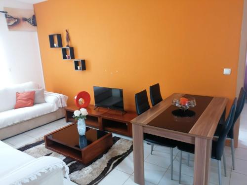 a living room with a table and a couch at Family Apartment in Praia