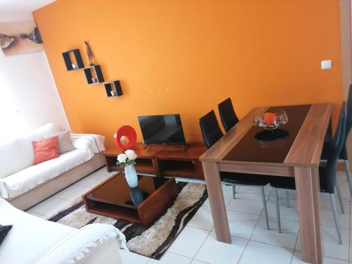 a living room with a table and a couch at Family Apartment in Praia