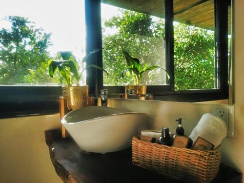 Un baño con bañera, lavabo y ventana. en Suites Tulum, en Tulum