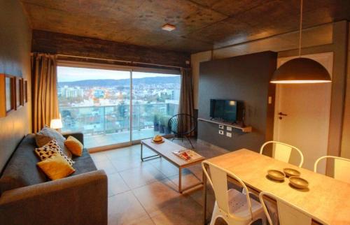a living room with a couch and a table with a view at Naranjo 9D in San Salvador de Jujuy